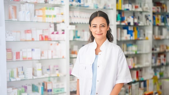 Female pharmacists smiles into the camera.