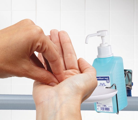 Manos realizando una desinfección con Sterillium med, en un entorno hospitalario