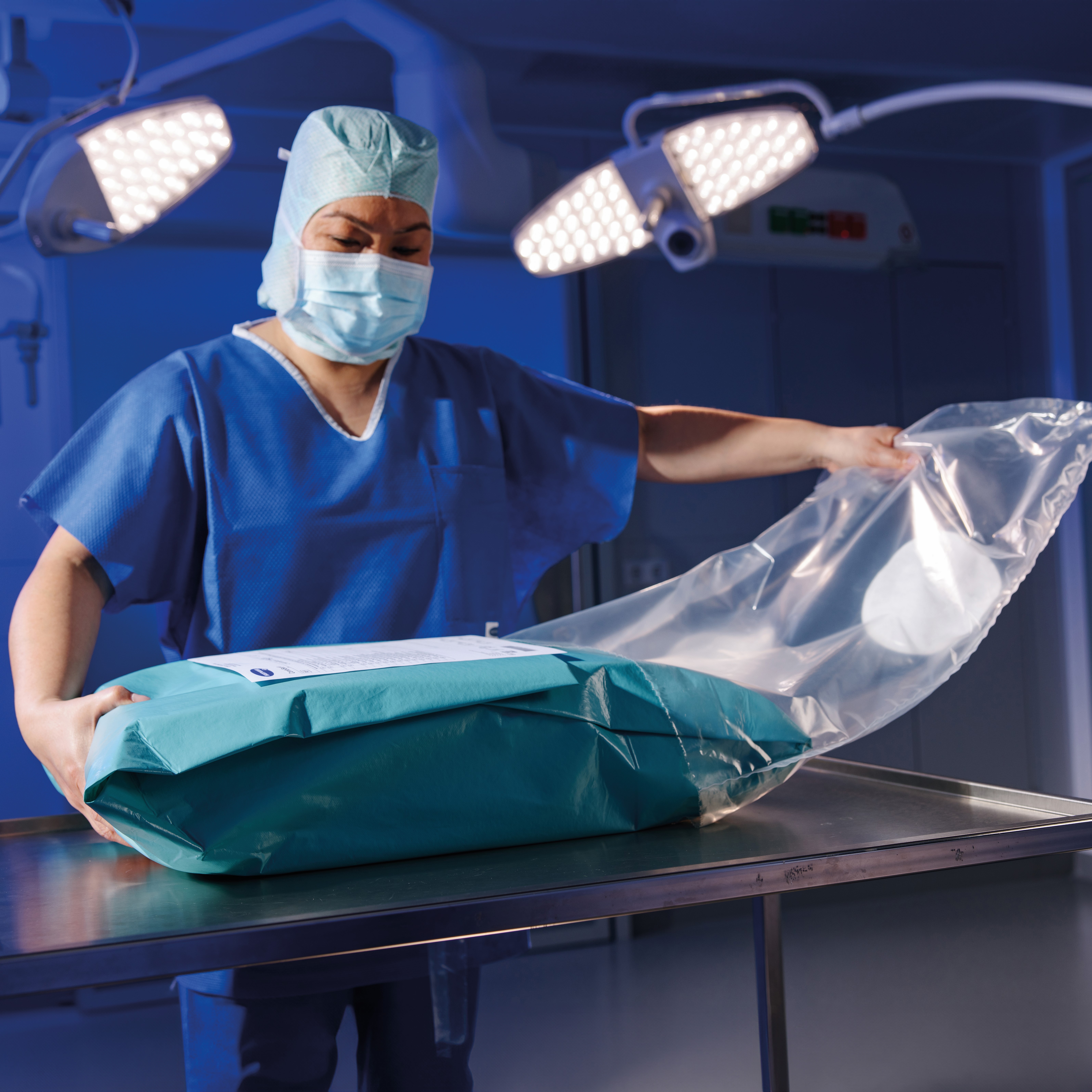 Medizinische Fachkraft in OP-Kleidung hantiert mit einem sicher verpackten, sterilen Set im OP – Fokus auf Hygiene und Kontrolle.