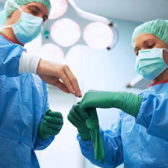 OP-Assistenz hilft Operateur beim Anlegen der Double Gloves