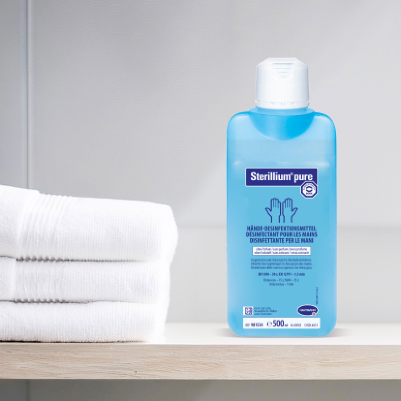 A bottle of Sterillium® next to a pile of towels.