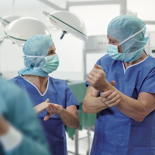 Two surgeons disinfect their hands.