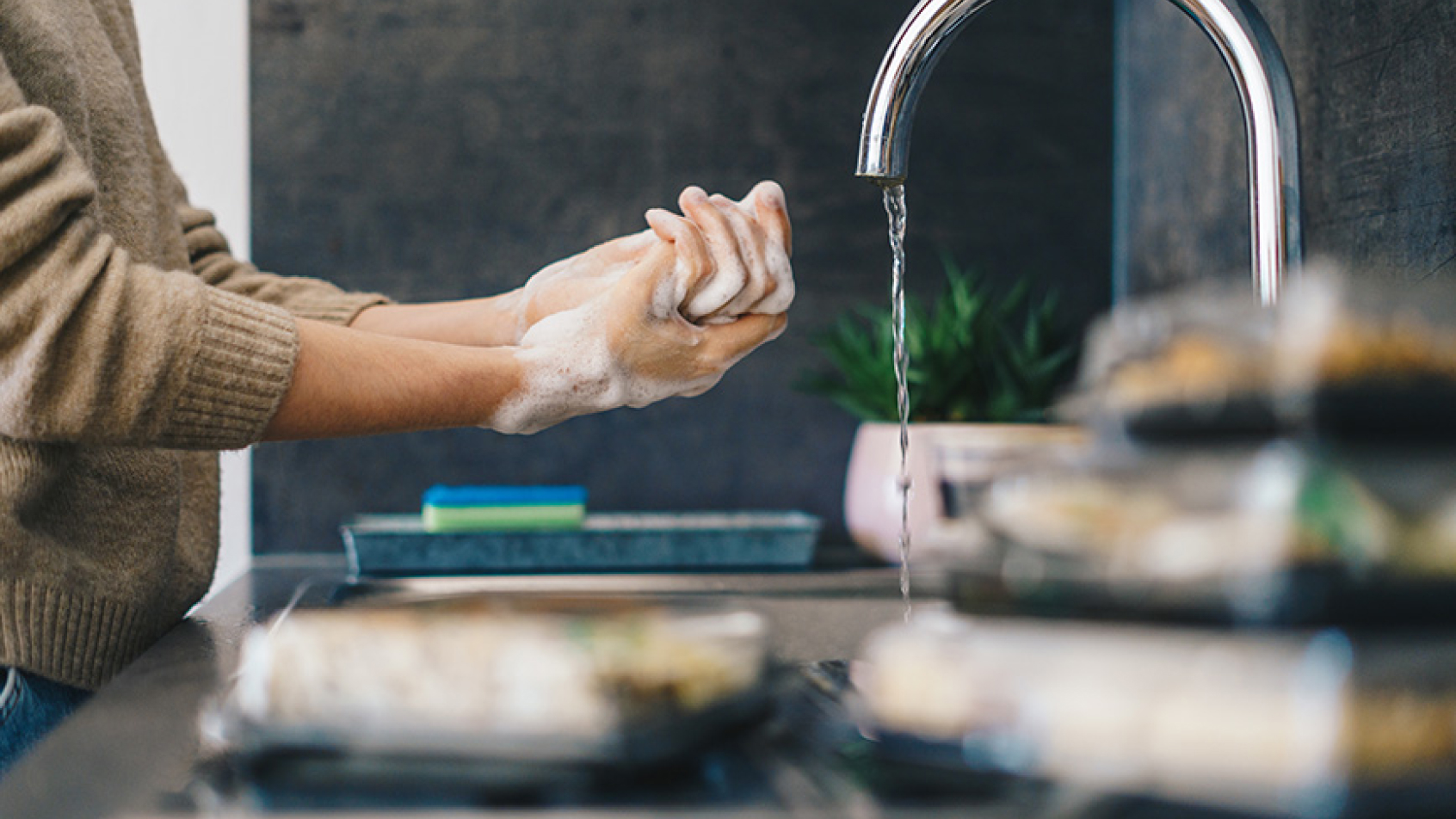 Person washing hands in the kitchen.