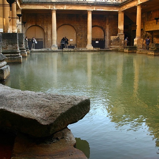 Das innere Becken eines antiken Badehauses, umgeben von Steinsäulen.