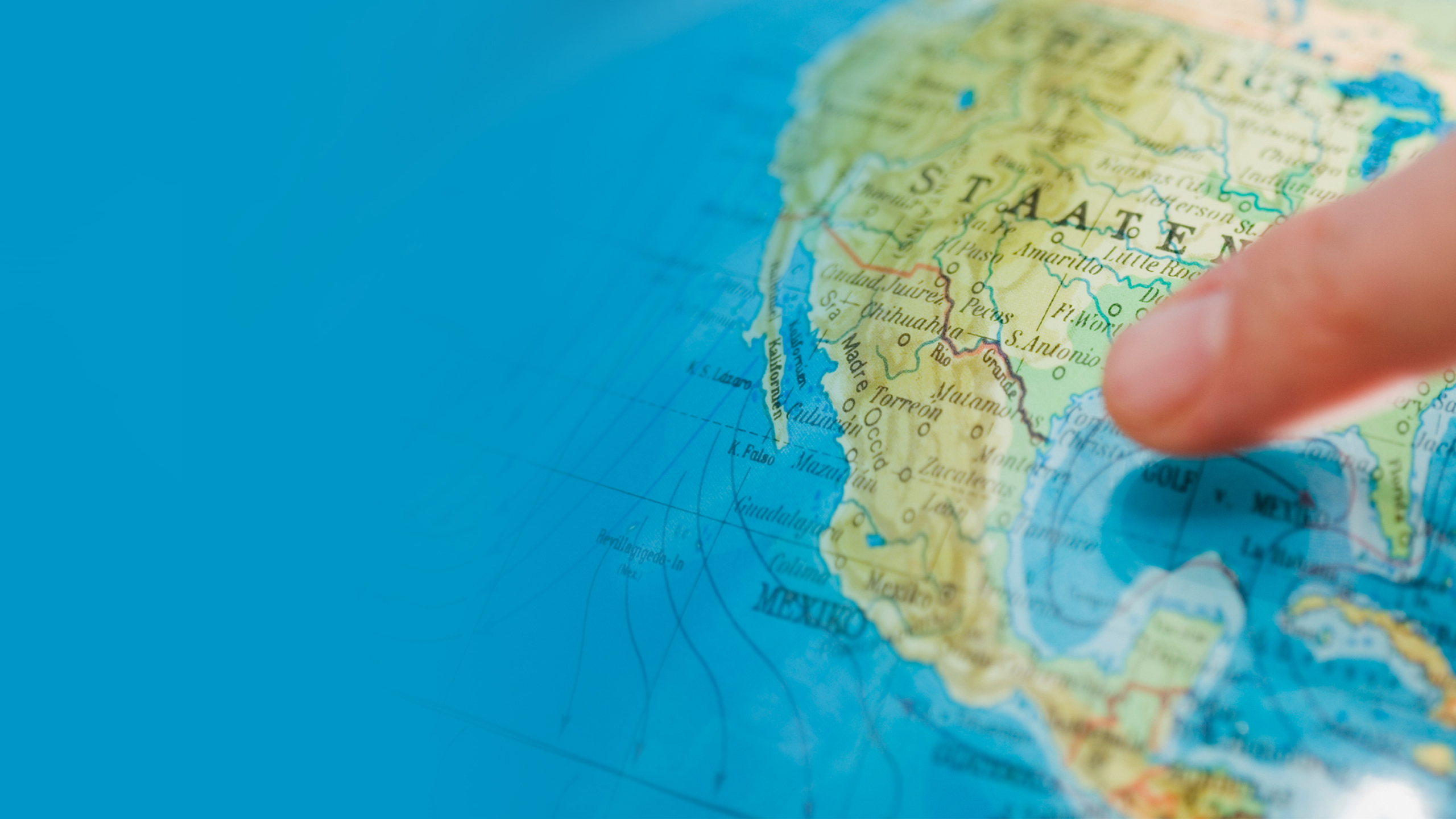 Someone points to the USA on a globe with their index finger.