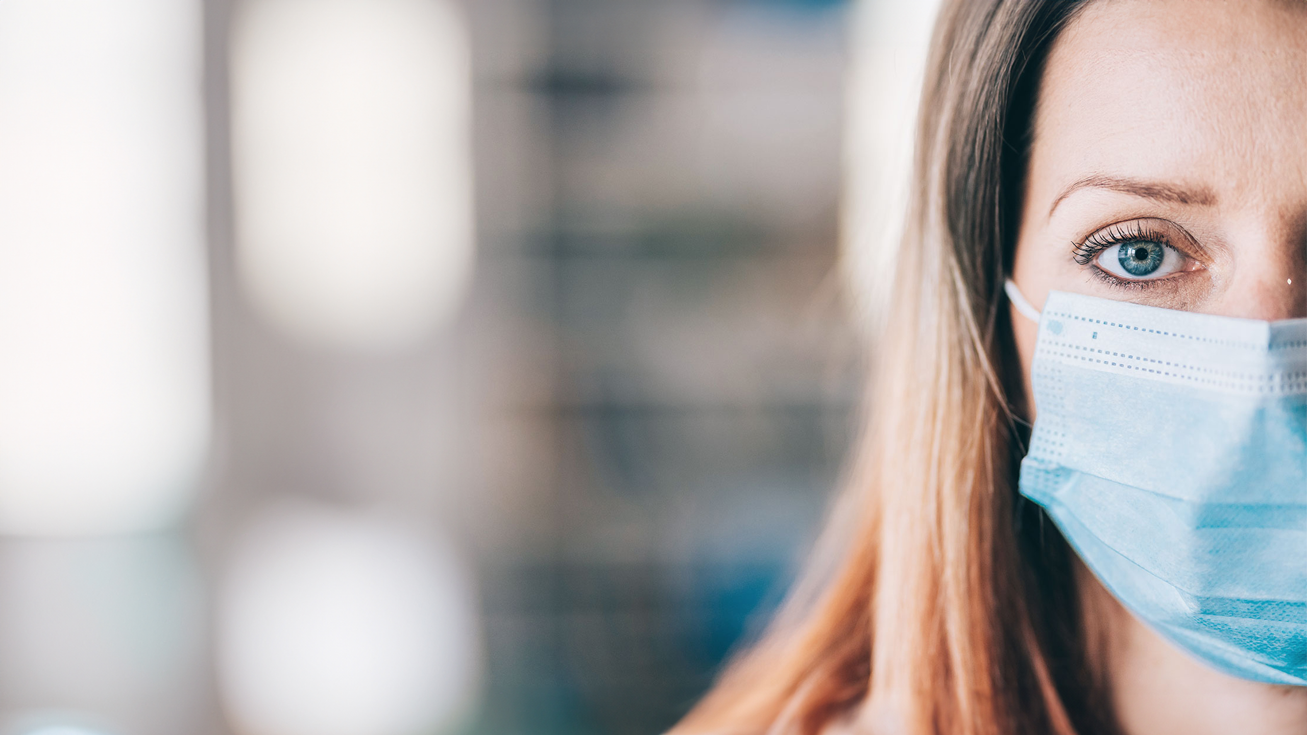 Portrait of a blonde woman wearing a facemask.