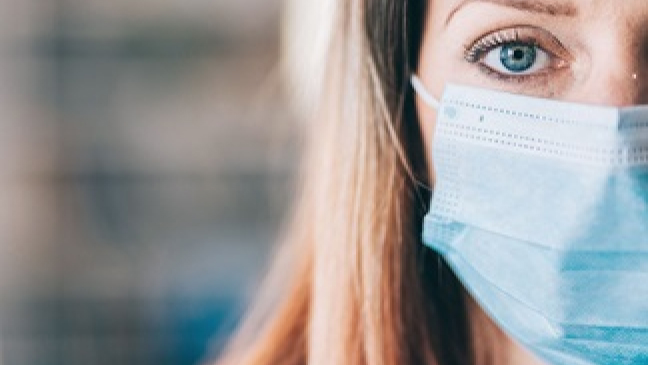 Portrait of a blonde woman wearing a facemask.
