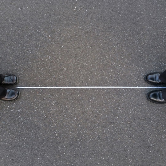 Image from above of shoes facing each other but with a wide distance between them.