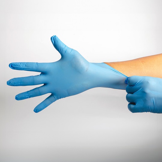 Hände ziehen blaue Untersuchungshandschuhe an