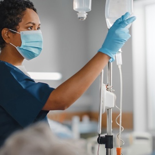Eine Krankenschwester überprüft einen Infusionsbehälter.