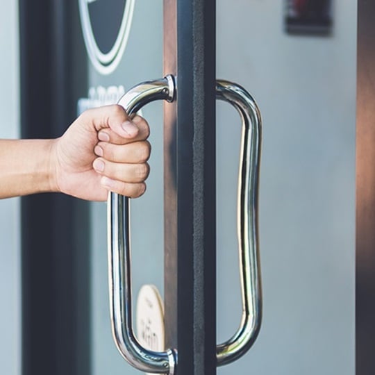 A hand clasping a door handle.