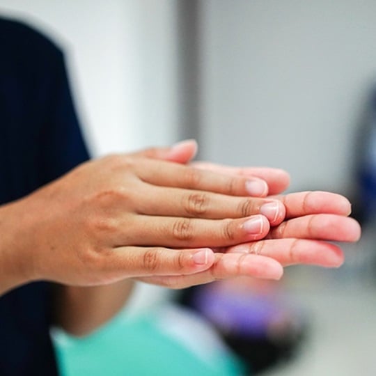 A woman disinfects her hands.
