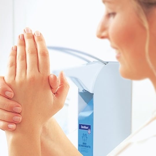 Woman applying disinfectant on her hands.