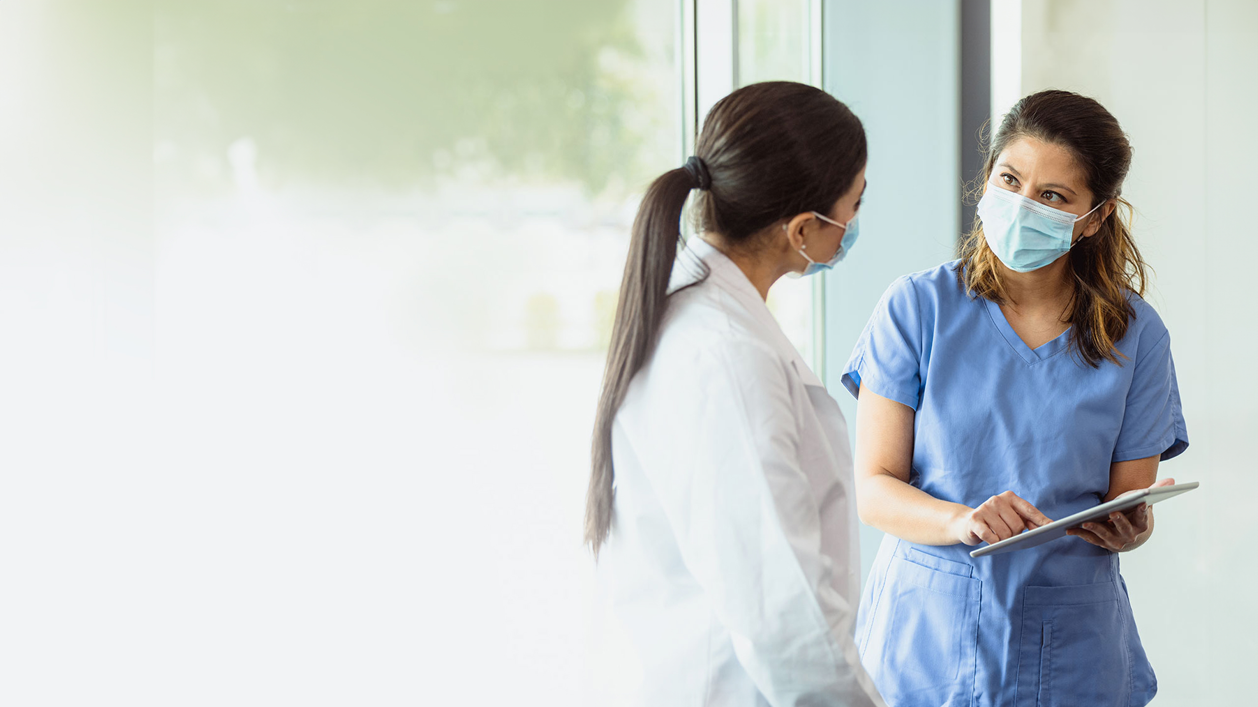 Photo of female doctor and female nurse talking to each other.