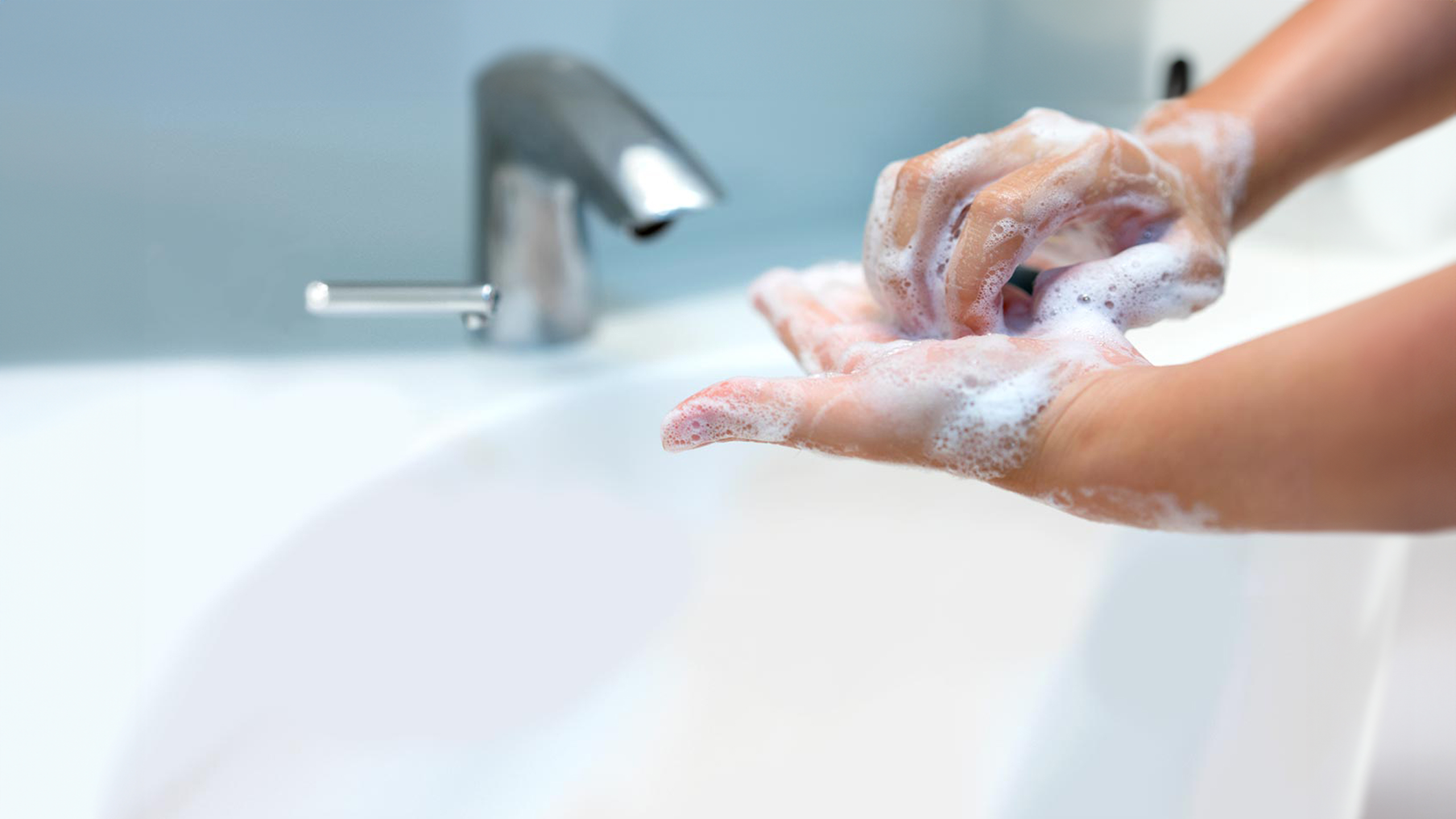 Close up of hands being washed thoroughly. 