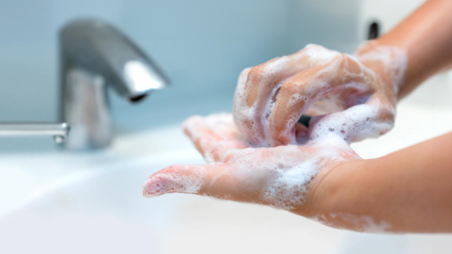 Close up of hands being washed thoroughly. 