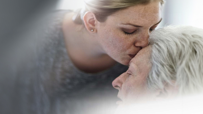 Daughter caring for mother in hospital.