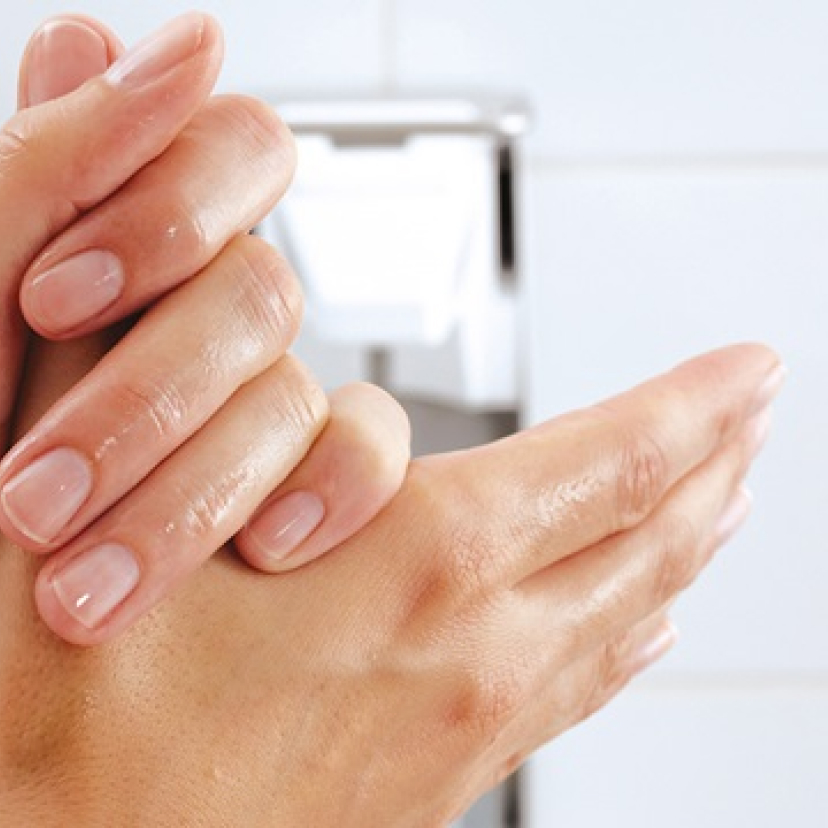 Photo of hands applying disinfectant.