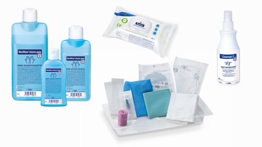 A selection of medical care products including disinfectant bottles, sanitizing wipes, a spray bottle, and a bandage kit on a white background.
