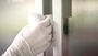Close up of a hand wearing a glove and cleaning a frame.