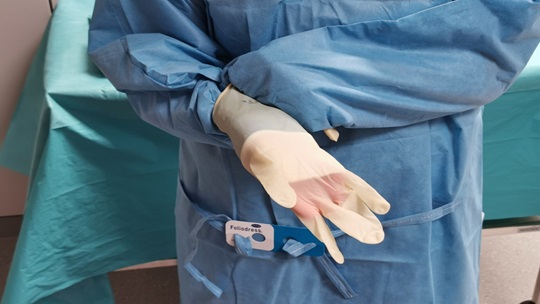 Die Abbildung zeigt, wie die Stulpe hochgezogen und die Finger in den Handschuh eingeführt werden.