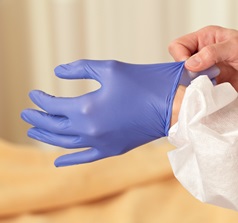 Two hands putting on sterile gloves. 