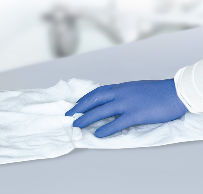 Teaser Hand in blauen Handschuhen putzen Oberfläche mit Bacillol