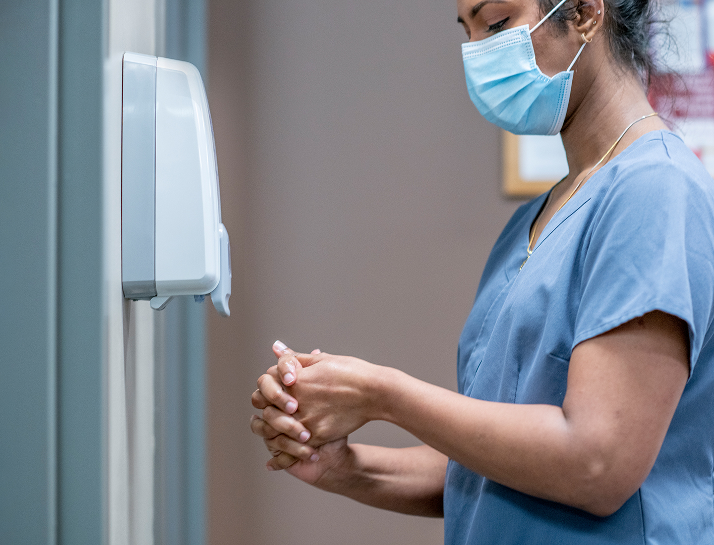 Health care professional disinfects her hands