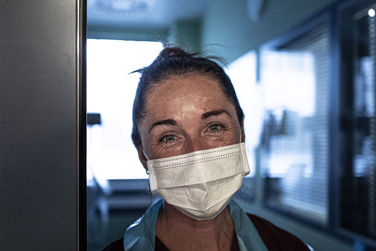 Nurse with face mask on smiling into camera
