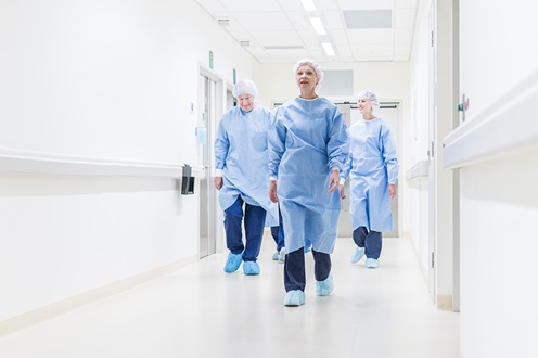 Doctors in personal protective equipment walking down a hospital hallway