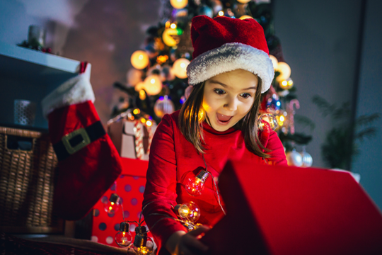 Een klein meisje betoverd door de magie van Kerstmis