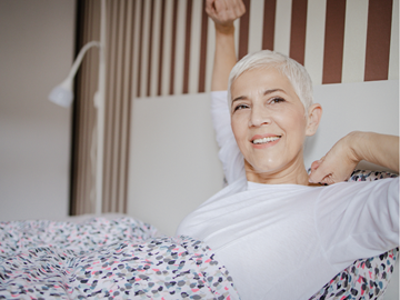 Vrouw wordt ontspannen wakker in haar bed