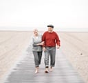 An elder couple is walking at the sea
