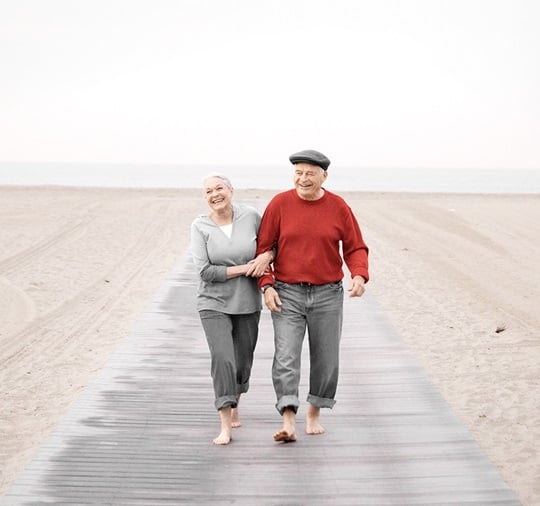 An elder couple is walking at the sea