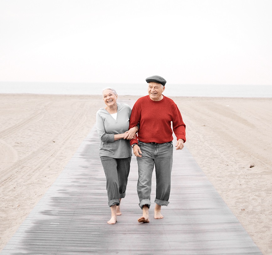 Un couple de personnes âgées marche à la mer