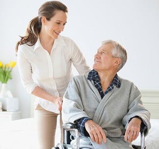 Pflegerin mit Patient im Rollstuhl