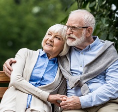 Seniorenpaar auf Bank sitzend