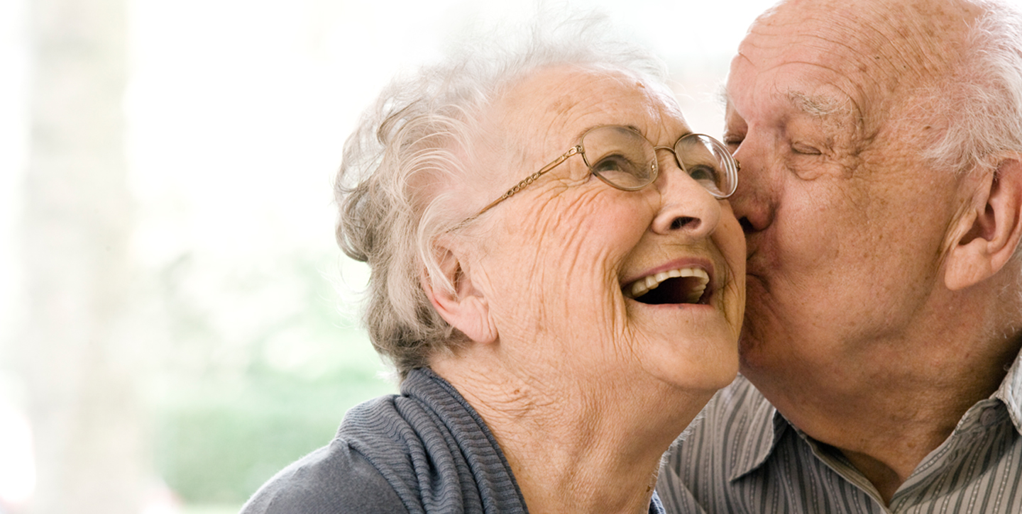 un abuelo besando a una abuela en la mejilla