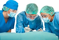 three surgeons doing a surgery wearing blue gowns and head an