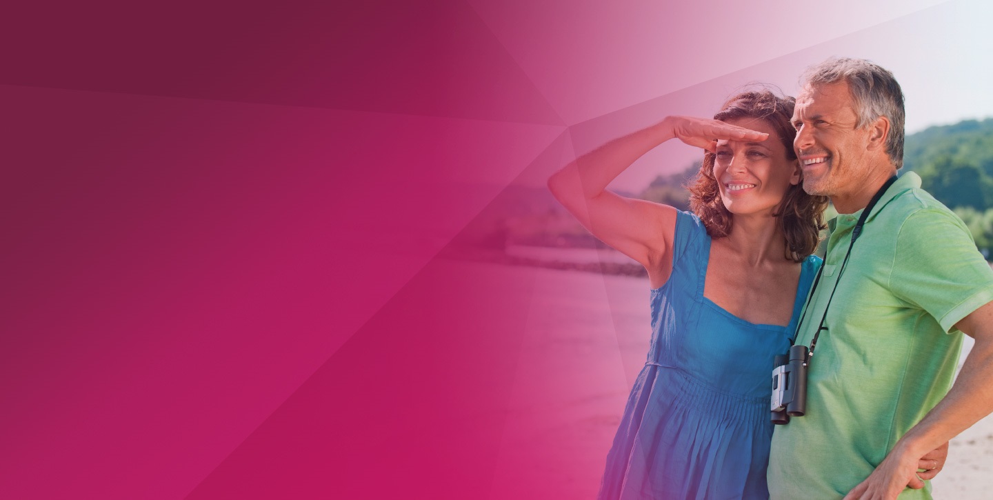 couple smiling looking at something pink background