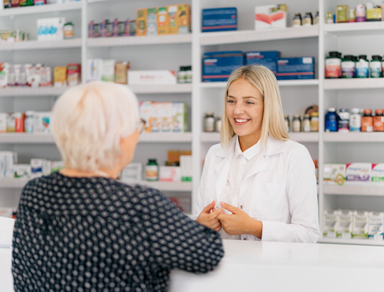 Young female pharmacist advising female senior in a pharmacy